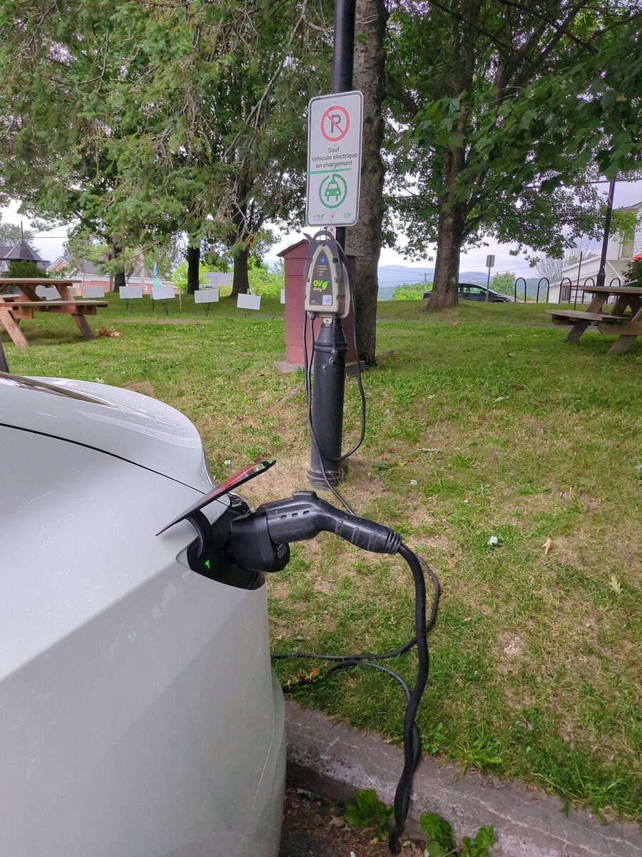 A Tesla plugged in at a public Level 2 charging station